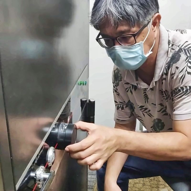 Uncle Thomas, Singapore safesmith, using a dial tool on the combination lock of a large stainless steel safe